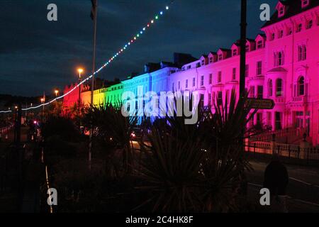 Llandudno , Wales, 26. Juni 2020. Llandudno Promenade wurde in den Farben des Regenbogens am Donnerstagabend zur Unterstützung der Pflegekräfte während der Coronavirus-Pandemie beleuchtet. Das Gebäude entlang der Promenade wurden beleuchtet, um die Anerkennung für die NHS-Mitarbeiter, Pflegekräfte und andere Schlüsselarbeiter zu zeigen Kredit : Mike Clarke Alamy Live News Stockfoto