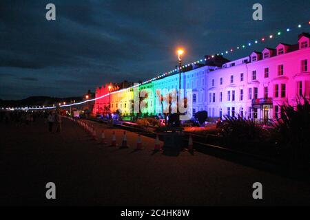 Llandudno , Wales, 26. Juni 2020. Llandudno Promenade wurde in den Farben des Regenbogens am Donnerstagabend zur Unterstützung der Pflegekräfte während der Coronavirus-Pandemie beleuchtet. Das Gebäude entlang der Promenade wurden beleuchtet, um die Anerkennung für die NHS-Mitarbeiter, Pflegekräfte und andere Schlüsselarbeiter zu zeigen Kredit : Mike Clarke Alamy Live News Stockfoto