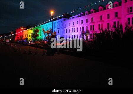 Llandudno , Wales, 26. Juni 2020. Llandudno Promenade wurde in den Farben des Regenbogens am Donnerstagabend zur Unterstützung der Pflegekräfte während der Coronavirus-Pandemie beleuchtet. Das Gebäude entlang der Promenade wurden beleuchtet, um die Anerkennung für die NHS-Mitarbeiter, Pflegekräfte und andere Schlüsselarbeiter zu zeigen Kredit : Mike Clarke Alamy Live News Stockfoto