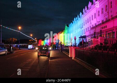 Llandudno , Wales, 26. Juni 2020. Llandudno Promenade wurde in den Farben des Regenbogens am Donnerstagabend zur Unterstützung der Pflegekräfte während der Coronavirus-Pandemie beleuchtet. Das Gebäude entlang der Promenade wurden beleuchtet, um die Anerkennung für die NHS-Mitarbeiter, Pflegekräfte und andere Schlüsselarbeiter zu zeigen Kredit : Mike Clarke Alamy Live News Stockfoto