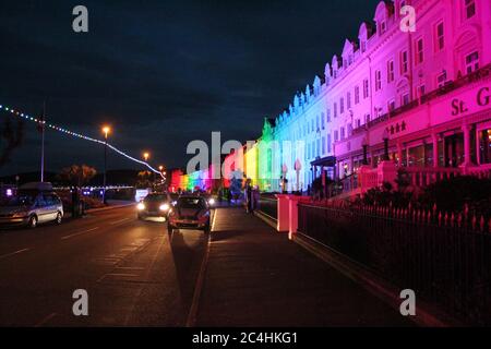 Llandudno , Wales, 26. Juni 2020. Llandudno Promenade wurde in den Farben des Regenbogens am Donnerstagabend zur Unterstützung der Pflegekräfte während der Coronavirus-Pandemie beleuchtet. Das Gebäude entlang der Promenade wurden beleuchtet, um die Anerkennung für die NHS-Mitarbeiter, Pflegekräfte und andere Schlüsselarbeiter zu zeigen Kredit : Mike Clarke Alamy Live News Stockfoto