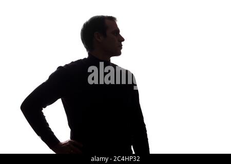 Porträt eines jungen Mannes, Hand auf Hüften, Seitenansicht - Silhouette Stockfoto