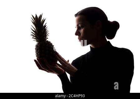 Ananas auf den Händen einer Frau auf weißem Hintergrund - Silhouette Stockfoto