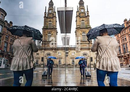 Glasgow, Schottland, Großbritannien. Juni 2020. 27 Starker Regen im Stadtzentrum von Glasgow, wenn die Öffentlichkeit mit Sonnenschirmen an Schaufenstern vorbeiläuft Iain Masterton/Alamy Live News Stockfoto