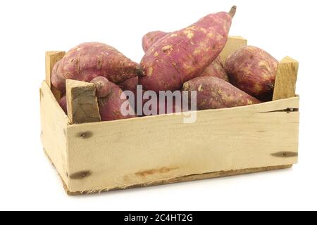 Frisch geerntete Süßkartoffeln in einer Holzkiste auf weißem Hintergrund Stockfoto