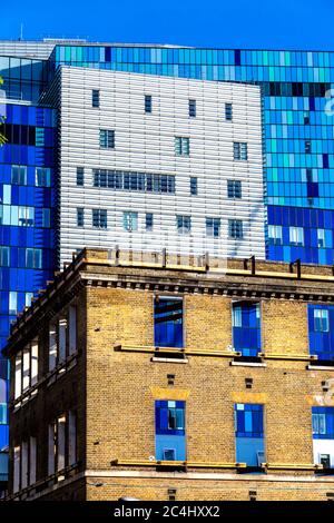 Die ursprüngliche, erhaltene Fassade des alten Royal London Hospital, das in ein Rathaus für Tower Hamlets umgewandelt wurde, und das neue Royal London Hospital im Hintergrund Stockfoto