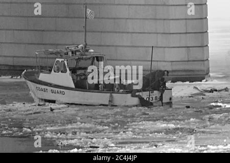 Die Rettungs- und Such-Teams der US-Küstenwache befreien den Körper eines Opfers des Flugs 90 von Air Florida aus dem gefrorenen Wasser des Potomac River am 14. Januar 1982 in Washington, DC.der US-Inlandsflug stürzte in den Fluss, nachdem er am 13. Januar 1982 mit der 14. Street Bridge zusammenstieß und 74 Menschen tötete. Stockfoto