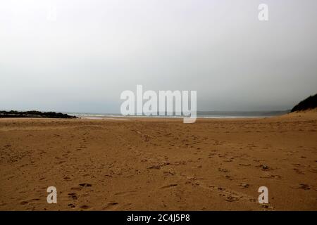 Menschenleerer Küstenstrand an einem neblig regnerischen Sommerabend Stockfoto