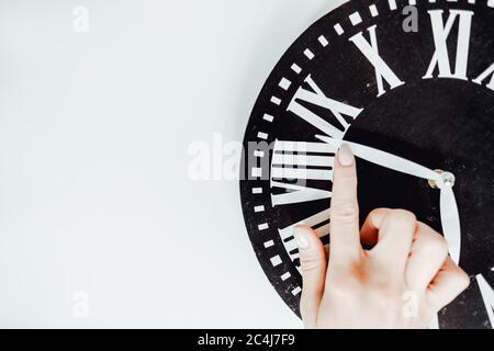 Hand übersetzt einen Pfeil auf der Uhr. Stockfoto