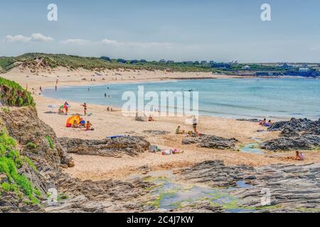 Ein wunderschöner Tag, um an einem Sandstrand am ruhigen, türkisblauen Atlantik in Constantine Bay, Cornwall, England, zu schwimmen, zu surfen und sich zu sonnen. Stockfoto