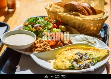 Israelischer Frühstücksteller in jedem Café in Israel gefunden, dieser Teller hat alles, was gute Eier pro die Gäste verlangen, verschiedene Käse und Gewürze, frischen israelischen Salat und ein Brotkorb. Stockfoto