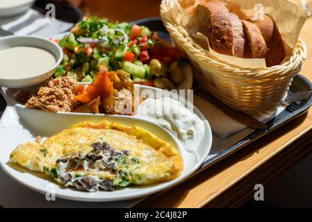 Israelischer Frühstücksteller in jedem Café in Israel gefunden, dieser Teller hat alles, was gute Eier pro die Gäste verlangen, verschiedene Käse und Gewürze, frischen israelischen Salat und ein Brotkorb. Stockfoto
