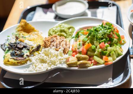 Israelischer Frühstücksteller in jedem Café in Israel gefunden, dieser Teller hat alles, was gute Eier pro die Gäste verlangen, verschiedene Käse und Gewürze, frischen israelischen Salat und ein Brotkorb. Stockfoto