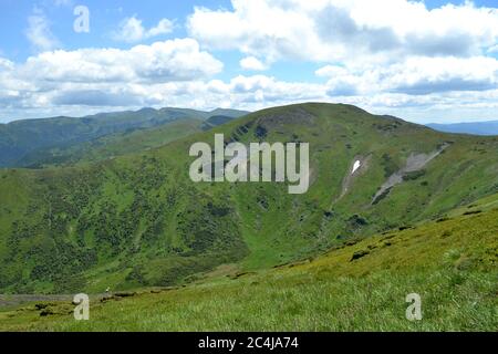 Die herrliche Landschaft der Karpaten im Sommer, ein Stück Schnee in Form eines Herzens auf dem Hang Stockfoto