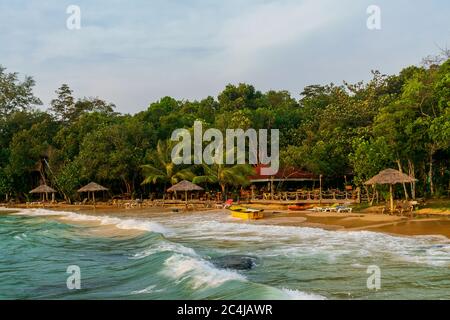 Ein schöner Strand mit Sonnenschirmen, Liegestühlen und Booten am Long Set Beach, Koh Rong, Kambodscha Stockfoto