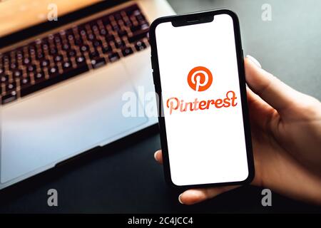 Hände halten das iPhone X mit Pinterest App Logo auf dem Bildschirm. Stockfoto