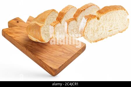 Brotscheiben fliegen über ein hölzernes Schneidebrett isoliert auf weiß Stockfoto