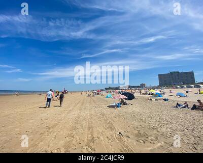 Zandvoort, Niederlande - Juni 26. 2020: Blick auf Sandstrand mit Sonnenschirmen auf holländische Nordsee im Sommer mit blauem Himmel und wenigen Zirruswolken Stockfoto