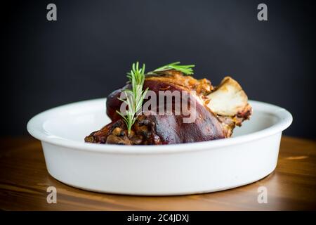 Gebackener Schweinehüchel mit Gewürzen in keramischer Form Stockfoto