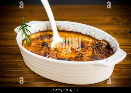 Gebackenes Fleisch mit Gewürzen Gemüse und Soße in keramischer Form Stockfoto