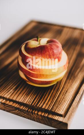 Roter Apfel in Ringe auf einem Holzbrett geschnitten. Nahaufnahme Stockfoto