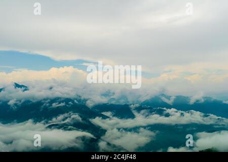 Ein schöner Blick auf die niedrigen Monsunwolken über die Bergketten bei Sonnenuntergang, Mussoorie, Uttarakhand, Indien Stockfoto