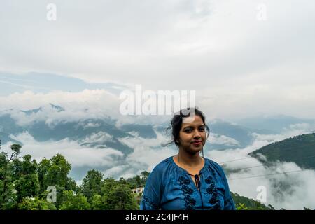 Eine Frau, die den Blick auf die tief liegenden Monsunwolken genießt, Mussoorie, Uttarakhand, Indien Stockfoto
