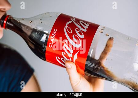 Mädchen trinkt Coca Cola aus einer Plastikflasche. Stockfoto