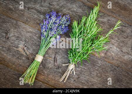 Aromatische und homöopathische Kräuter. Lavendel und Rosmarin bündeln sich auf einem Holztisch. Stockfoto