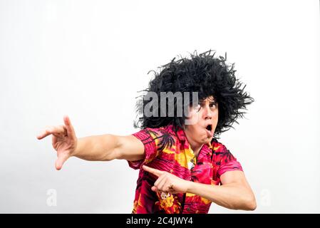 Mann mit Afro Perücke und hawaiihemd, sehr verrückt. Mittlerer Schuss. Weißer Hintergrund. Stockfoto