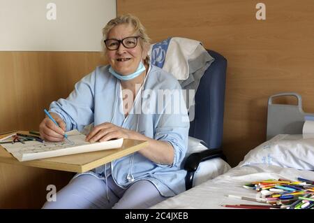 Im Krankenhaus eingewiesenen Frau verbringt sie ihre Freizeit Färbung Mandalas und andere Zeichnungen, hilft ihr zu entspannen und nicht zu denken. Stockfoto