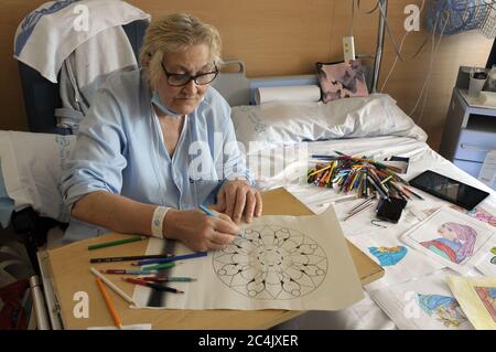 Im Krankenhaus eingewiesenen Frau verbringt sie ihre Freizeit Färbung Mandalas und andere Zeichnungen, hilft ihr zu entspannen und nicht zu denken. Stockfoto