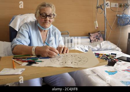 Im Krankenhaus eingewiesenen Frau verbringt sie ihre Freizeit Färbung Mandalas und andere Zeichnungen, hilft ihr zu entspannen und nicht zu denken. Stockfoto