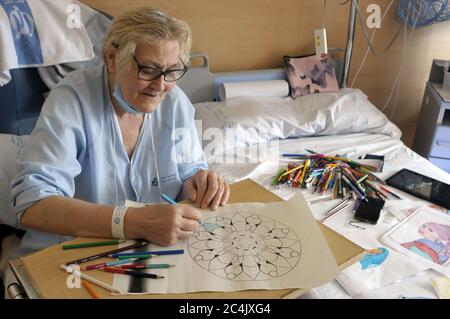 Im Krankenhaus eingewiesenen Frau verbringt sie ihre Freizeit Färbung Mandalas und andere Zeichnungen, hilft ihr zu entspannen und nicht zu denken. Stockfoto