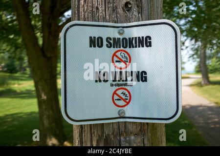 No Smoking und No Vaping Schild an einem Holzmast am Sunset Beach in Port Weller, Ontario, nahe dem Eingang zum Welland Canal. Juni 2020. Stockfoto