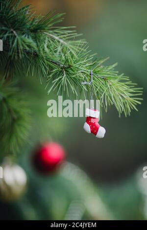 Nahaufnahme von Weihnachtsstrumpf als Dekoration, die an den Zweigen eines Weihnachtsbaums hängt. Weihnachten in warmen, Weihnachten ohne Schnee Stockfoto