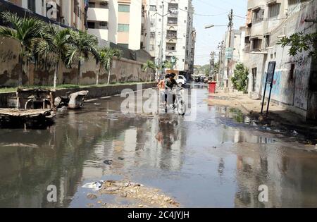 Überflutete Straße durch überlaufendes Abwasser verursacht Probleme für Pendler, zeigt Fahrlässigkeit der betroffenen Behörden, in Patel para in Karachi am Samstag, 27. Juni 2020. Stockfoto