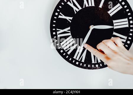 Hand übersetzt einen Pfeil auf der Uhr. Stockfoto