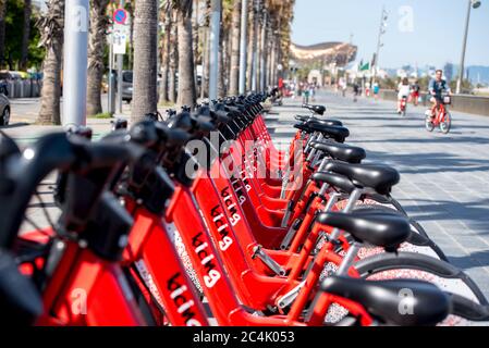 Barcelona, Spanien - 26. Juni 2020: Leuchtend rote Fahrräder zur Miete in einer Reihe in La Barceloneta geparkt. Konzept der ökologisch nachhaltigen tra Stockfoto