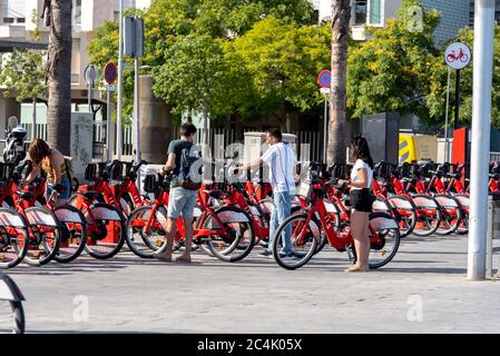 Barcelona, Spanien - 26. Juni 2020: Leuchtend rote Fahrräder zur Miete in einer Reihe in La Barceloneta geparkt. Konzept der ökologisch nachhaltigen tra Stockfoto