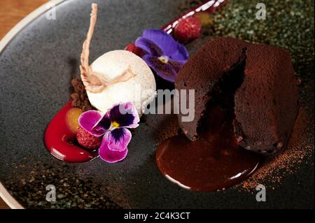 Gesundes Dessert-Thema. Brownie mit Eis und Blumen Gourmet Stockfoto