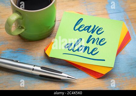 Lassen Sie mich in Ruhe - Handschrift auf einer grünen Haftnotiz mit einem Stift und einer Tasse Kaffee, geschäftliche und persönliche Themen Konzept Stockfoto