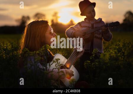 Mutter mit Töchtern, die mit Gitarre und Ukulele spielen. Stockfoto