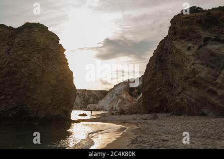 Ein dramatischer Sonnenuntergang über Firiplaka Beach in Milos, Griechenland Stockfoto