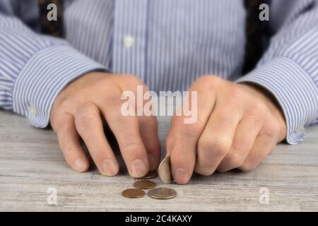 Nahaufnahme der rauen Hände eines älteren Mannes, der seinen Taschenwechsel zählt Stockfoto