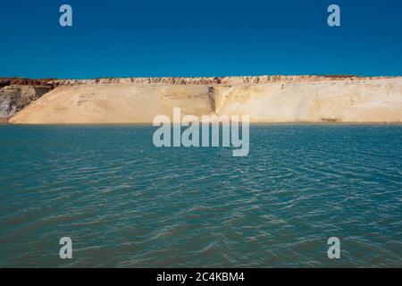 Teich in der Wüste. Weiße Sandberge und blaues Wasser und Himmel. Stockfoto