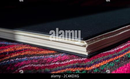 Ein geschlossenes schwarzes Hardcover-Skizzenbuch auf einer bunten Oberfläche Stockfoto