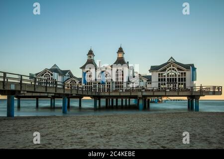 Historische Seebrücke an der Ostsee. Auf der Insel Rügen am Strandin Sellin Gebäude am Holzsteg am Abend. Blauer Himmel bei Sonnenuntergang Stockfoto