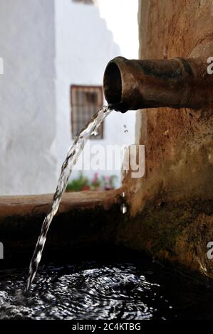Nahaufnahme des Wassers, das aus einem rostigen herauskommt Metallrohr Stockfoto