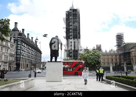 London, Großbritannien. Juni 2020. Polizisten stehen in der Nähe der Statue von Sir Winston Churchill auf dem Parliament Square, als ein Mann mit einem Schild "Jesus Chris starb für unsere Sünden Buße" vorbeigeht. Kredit: Paul Marriott/Alamy Live Nachrichten Stockfoto